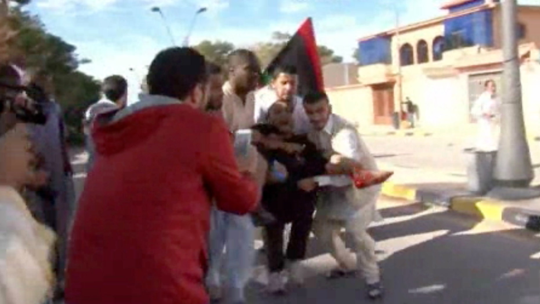 Nov. 15, 2015 - Image made from video shows an injured protester being carried away from the scene in Tripoli, Libya after militiamen attacked peaceful protesters demanding the disbanding of the country's rampant armed groups.