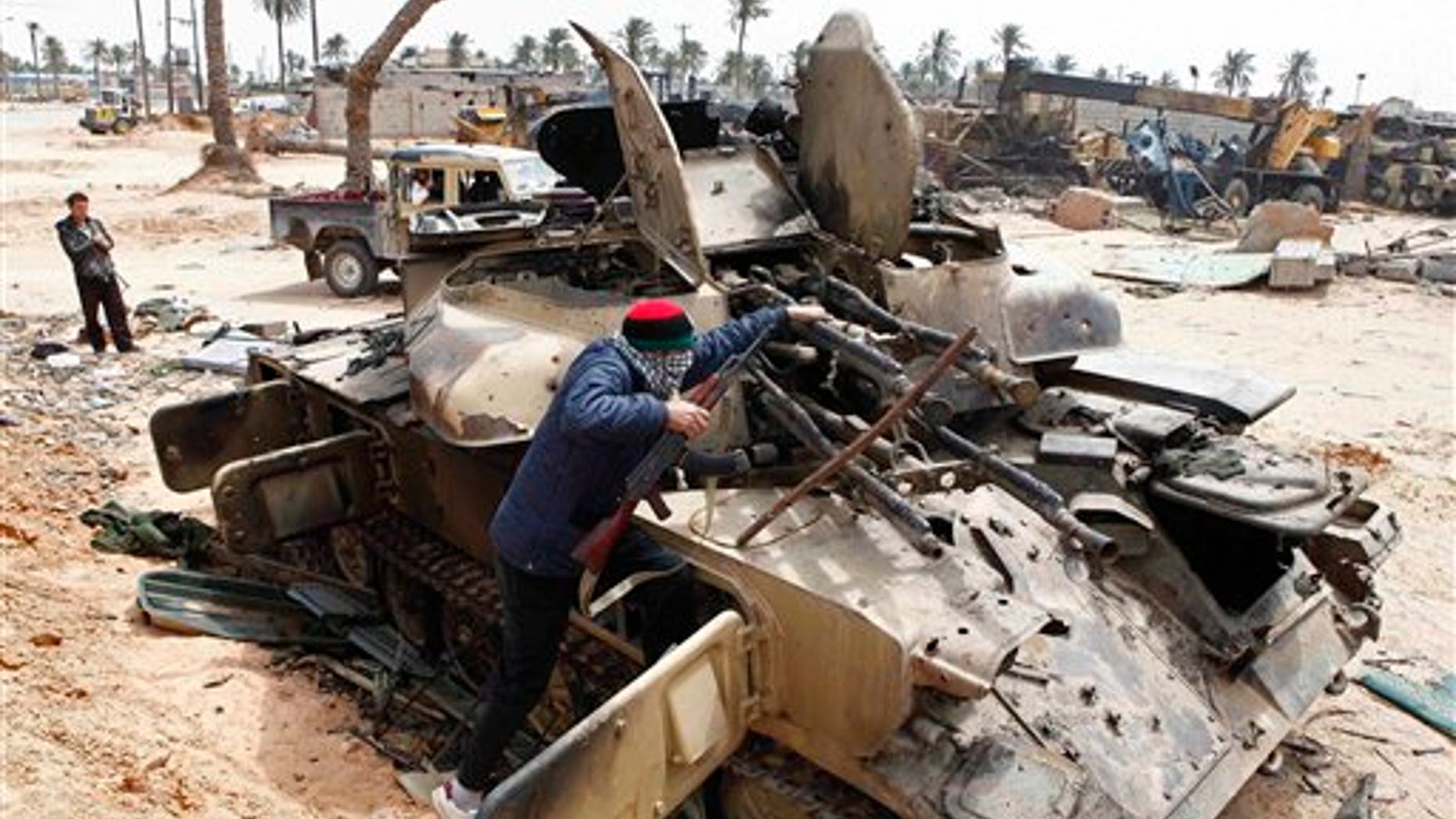April 22: A Libyan rebel fighter climbs on a destroyed government armored vehicle in the besieged city of Misrata, the main rebel holdout in Qaddafi's territory. (AP)
