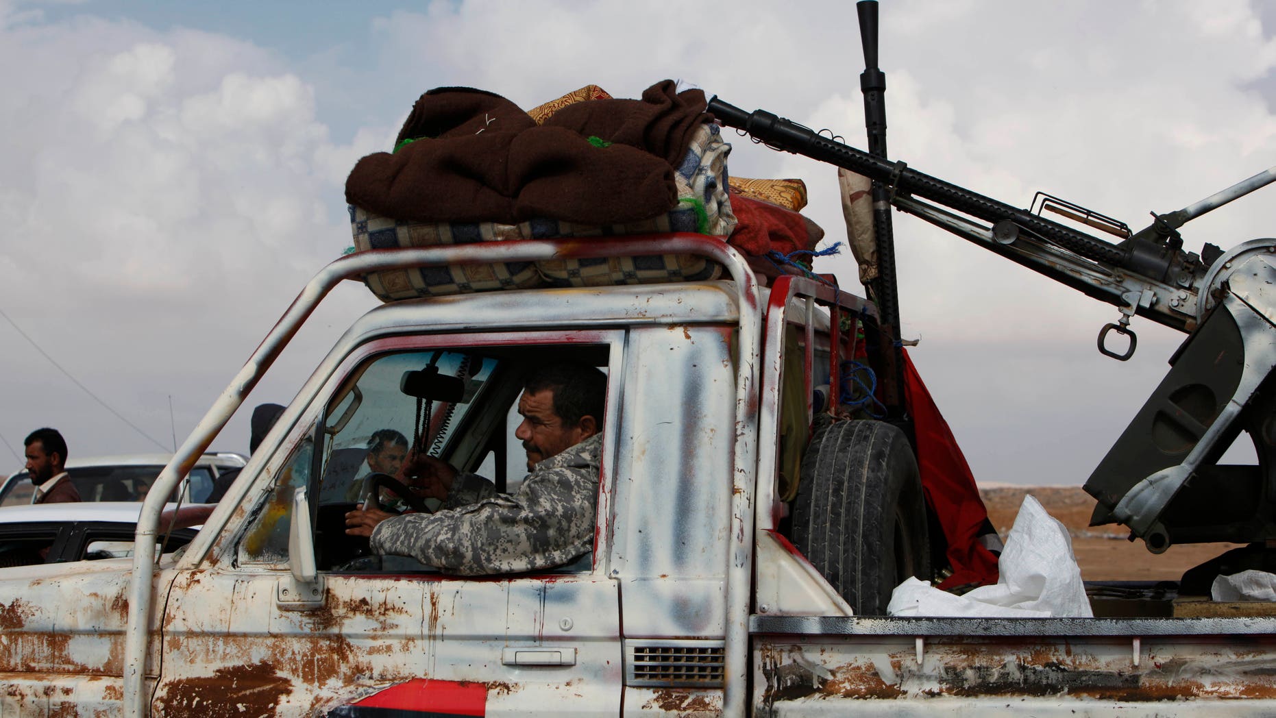 A Libyan rebel passes through the western gate of Ajdabiya, Libya on Friday, April 1, 2011. The western gate is closed for journalists and civilians trying to reach the front line of the conflict in Libya.