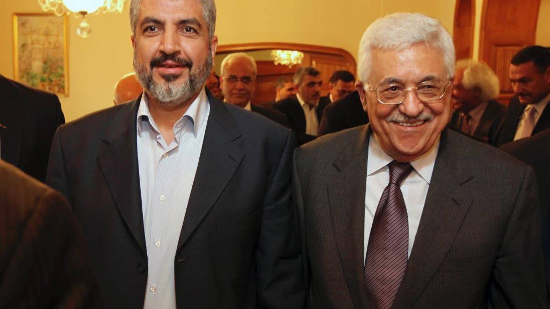 FILE - In this file photo provided on Nov. 24, 2011, by the office of Khaled Mashaal, Palestinian Hamas leader Khaled Mashaal, left, and Palestinian President Mahmoud Abbas are seen together during their meeting in Cairo, Egypt. A spokesman said Monday, May 5, 2014, that Mashaal and Abbas have held a rare meeting in Doha, Qatar, and agreed to move forward with a reconciliation deal between their rival movements. Abbas was in Doha for a grandson's college graduation. (AP Photo/Office of Khaled Meshaal, File)