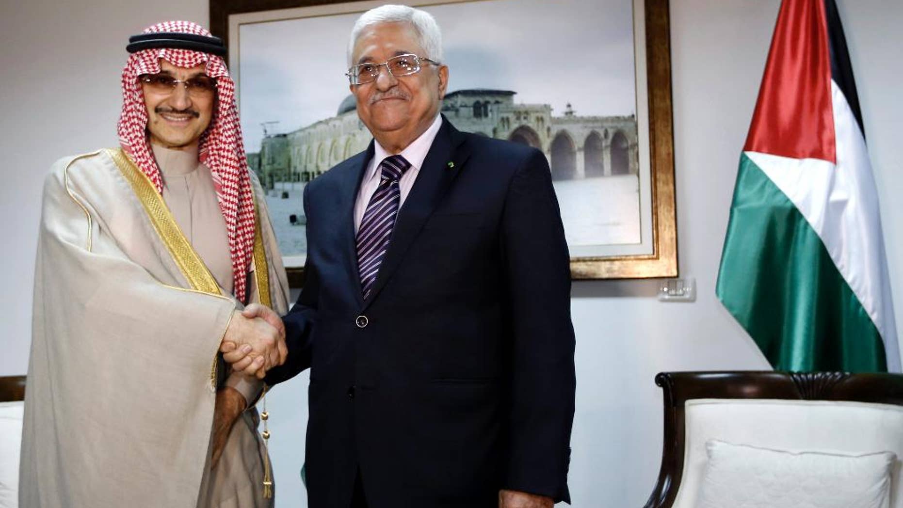 March 4, 2014 - Palestinian President Mahmoud Abbas, right, shakes hands with Saudi Prince Alwaleed bin Talal, during their meeting in the West Bank city of Ramallah.