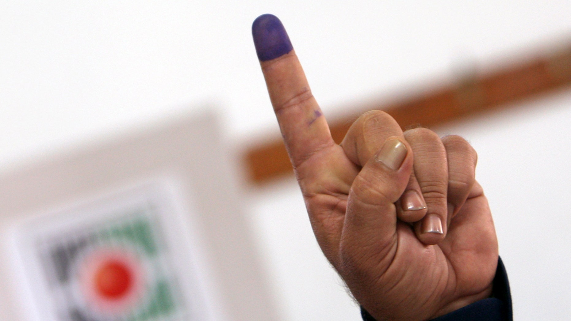 Oct. 18, 2012 - A Palestinian police officer shows his ink-stained finger after casting an early vote during local elections at a polling station in the West Bank town of Jenin.