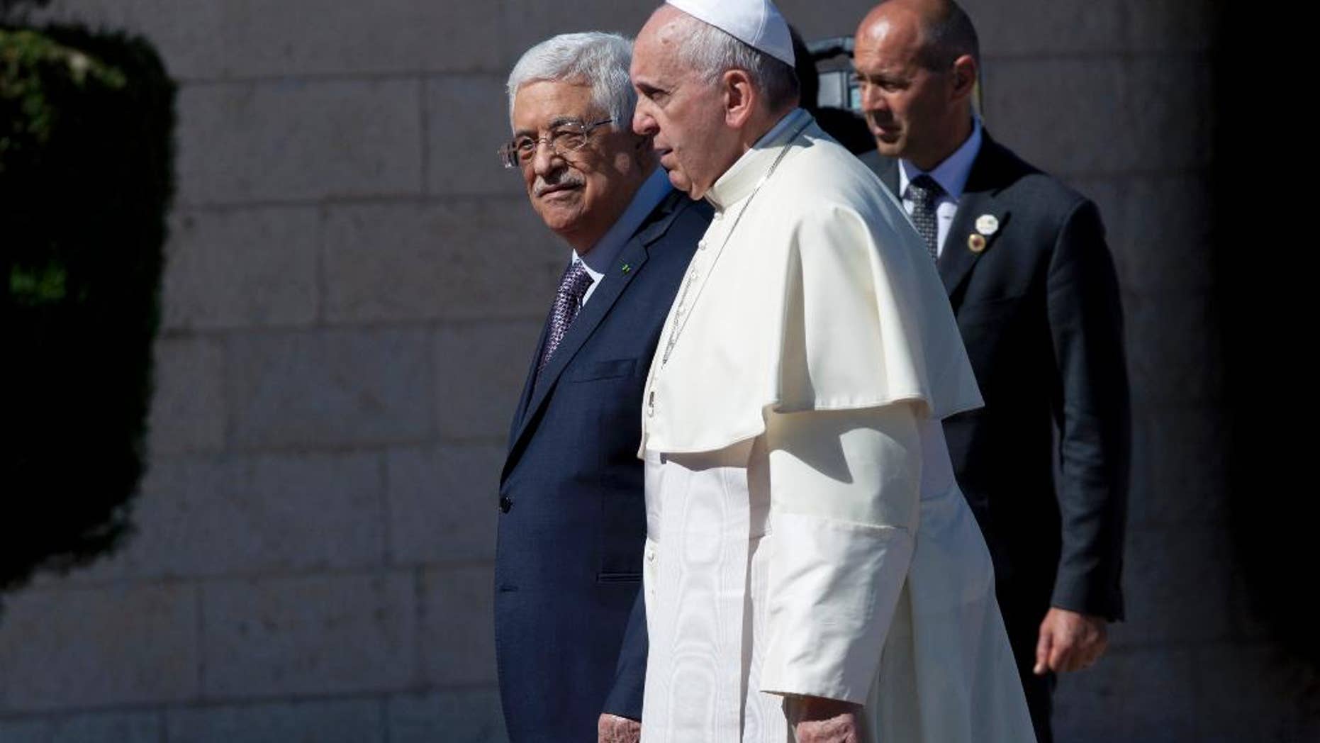 Palestinian President Mahmoud Abbas, left, receives Pope Francis upon his arrival at the Palestinian Authority headquarters in the West Bank city of Bethlehem on Sunday, May 25, 2014. Francis landed Sunday in the West Bank town of Bethlehem in a symbolic nod to Palestinian aspirations for their own state as he began a busy second day of his Mideast pilgrimage. (AP Photo/Nasser Nasser)