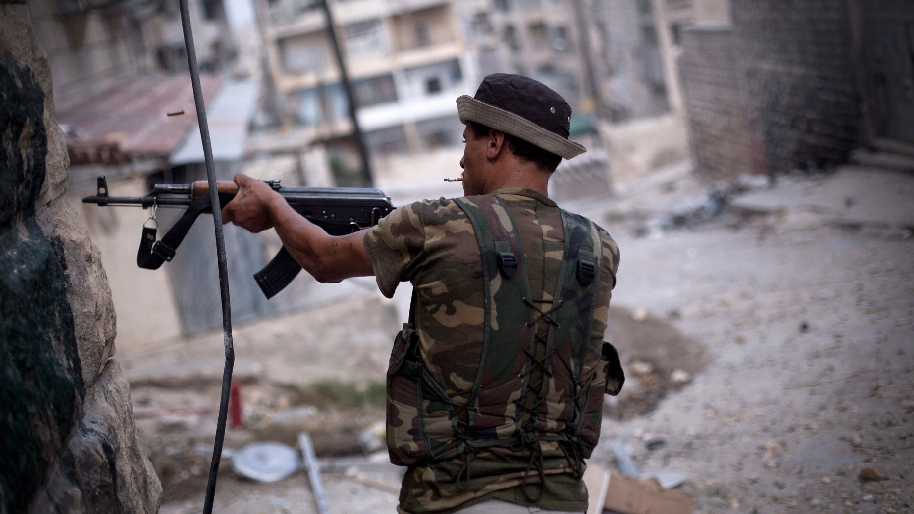 Sept. 11, 2012: In this file photo, A Free Syrian Army fighter fires his weapon at Syrian Army positions in Aleppo, Syria.