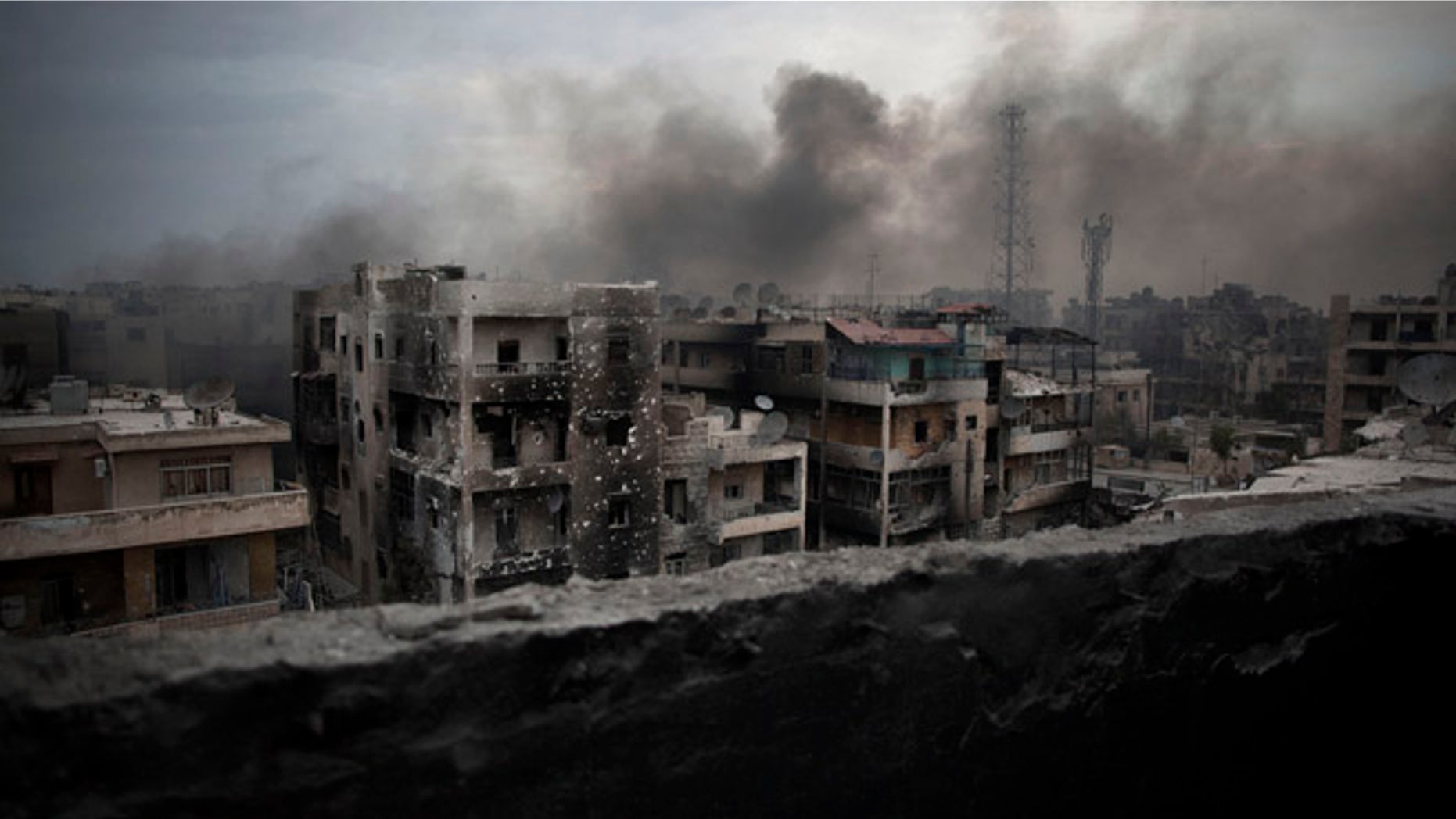 FILE - In this Tuesday, Oct. 2, 2012 file photo, smoke rises over Saif Al Dawla district, in Aleppo, Syria. Residents in the rebel-held districts of Aleppo have a reprieve from the incessant bombings by Syrian government warplanes and the promise of an end to the crippling siege that has left produce stalls bare. (AP Photo/ Manu Brabo, File)