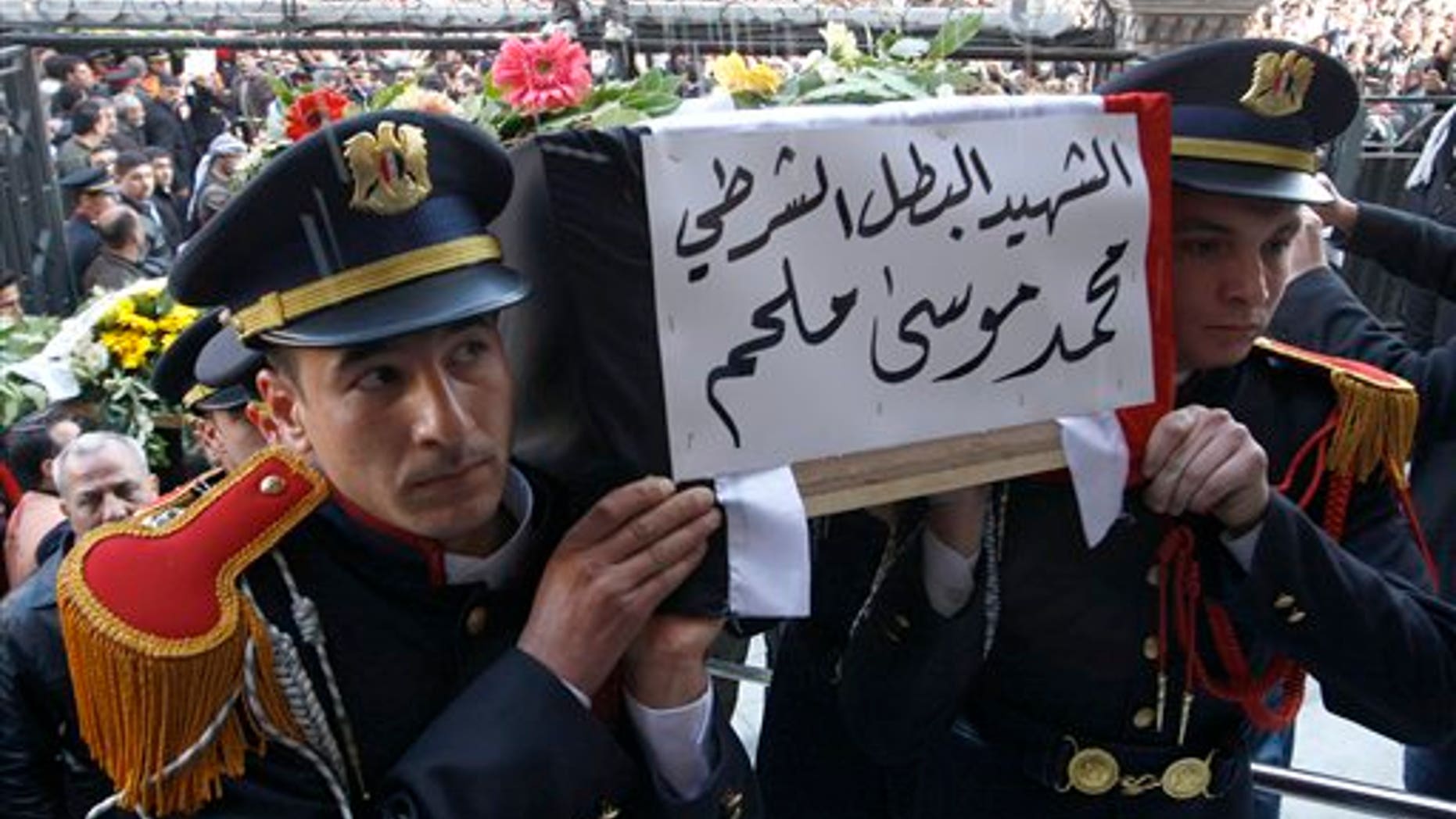 Jan. 7: Syrian police honor guards carry the coffin of one of 11 Syrian police officers who were killed in an explosion in the Midan neighborhood on Friday, during a mass funeral procession at Al-Hassan mosque, in Damascus, Syria.
