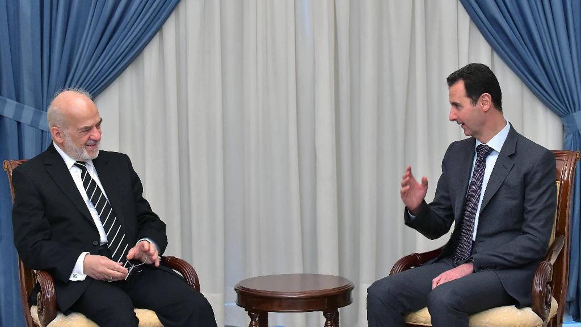 In this photo released by the Syrian official news agency SANA, Syrian president Bashar Assad, right, speaks with Iraqi Foreign Minister Ibrahim al-Jaafari, left, in Damascus, Syria, Tuesday, March. 24, 2015. Al-Jaafari said they discussed “Syrian and Iraqi issues, and the common dangers that threaten our security.” (AP Photo/SANA)