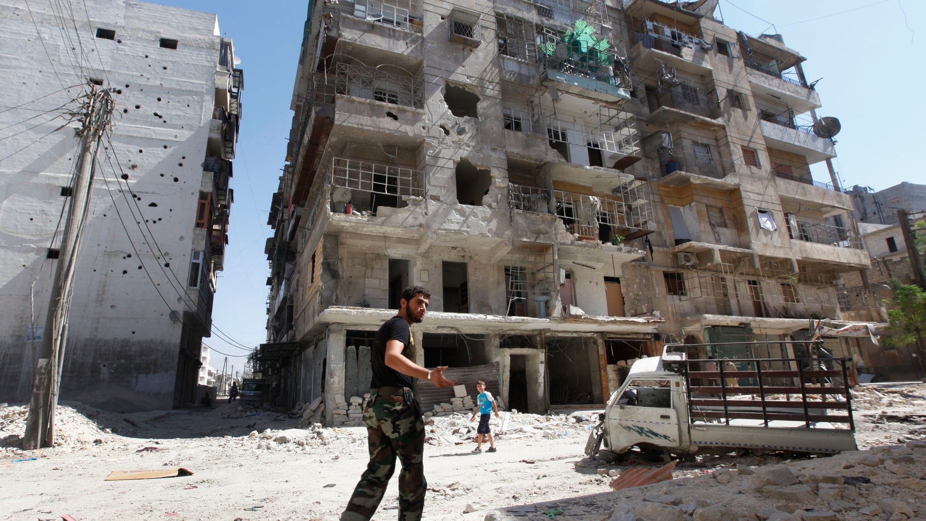A Frre Syrian Army soldier, walks next of a destroyed building that was attacked by a Syrian government airstrike earlier in the day at al-Shaar neighborhood, in Aleppo city, Syria, Monday Sept. 24, 2012. Most of those fighting the regime of President Bashar Assad are ordinary Syrians and soldiers who have defected, having become fed up with the authoritarian government, analysts say. But increasingly, foreign fighters and those adhering to an extremist Islamist ideology are turning up on the front lines. (AP Photo/Hussein Malla)
