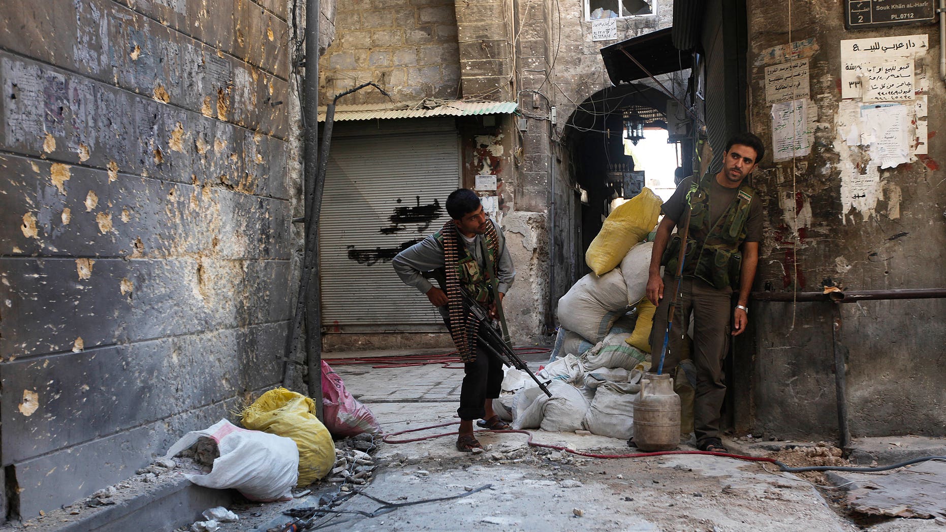 A Free Syrian Army soldier, right, looks towards a mirror which helps him see Syrian troops on the other side, as he takes his position with his comrade during fighting, at the old city of Aleppo city, Syria, Monday Sept. 24, 2012. Most of those fighting the regime of President Bashar Assad are ordinary Syrians and soldiers who have defected, having become fed up with the authoritarian government, analysts say. But increasingly, foreign fighters and those adhering to an extremist Islamist ideology are turning up on the front lines. (AP Photo/Hussein Malla)