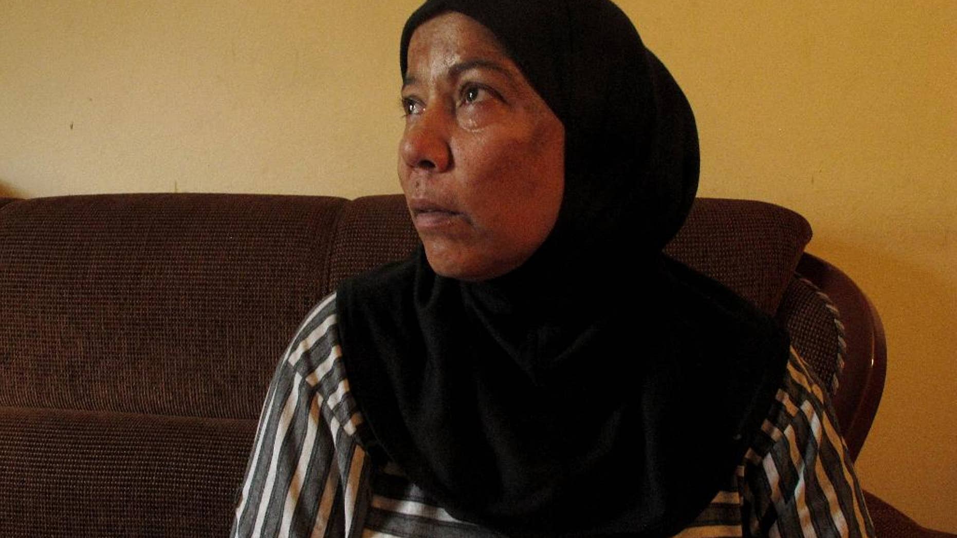 In this July 14, 2014 photo, Syrian refugee Umm Jamil looks on at her house in Halba town, northern Lebanon. Jamil, who takes care of her 19-year-old disabled son, said she was falsely accused of prostitution after Lebanese police confused her for another suspected prostitute in her building. Her brief detention left her feeling humiliated and wanting to leave Lebanon, where she said Syrian women are often seen as being sexually promiscuous. (AP Photo/Diaa Hadid)