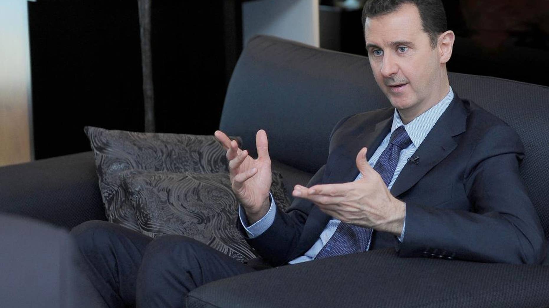 FILE - In this Monday, Aug. 26, 2013 file photo released by the Syrian official news agency SANA, Syrian President Bashar Assad gestures as he speaks during an interview with a Russian newspaper in Damascus, Syria. Assad said Thursday, March 6, 2014, that Russia's military takeover of Crimea reflects President Vladimir Putin's "wise policy" and his efforts to restore "security and stability" in Ukraine after an "attempted coup." (AP Photo/SANA, File)