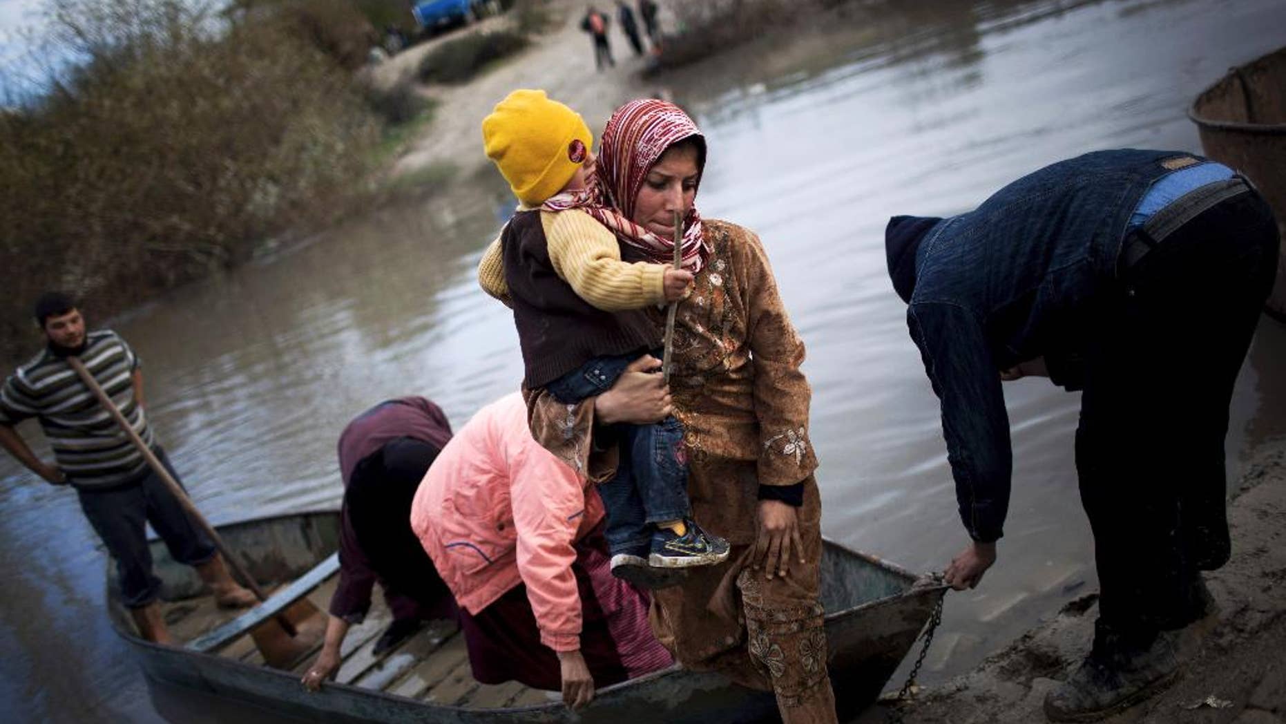 FILE - In this Dec. 8, 2012, file photo, Syrian refugees cross from Syria to Turkey by the Orontes river, near the village of Hacipasa, Turkey. Across the region women lead about a quarter of all Syrian refugee families, which number some 145,000, the United Nations estimated in a report issued Tuesday, July 8, 2014. (AP Photo/Manu Brabo, File)