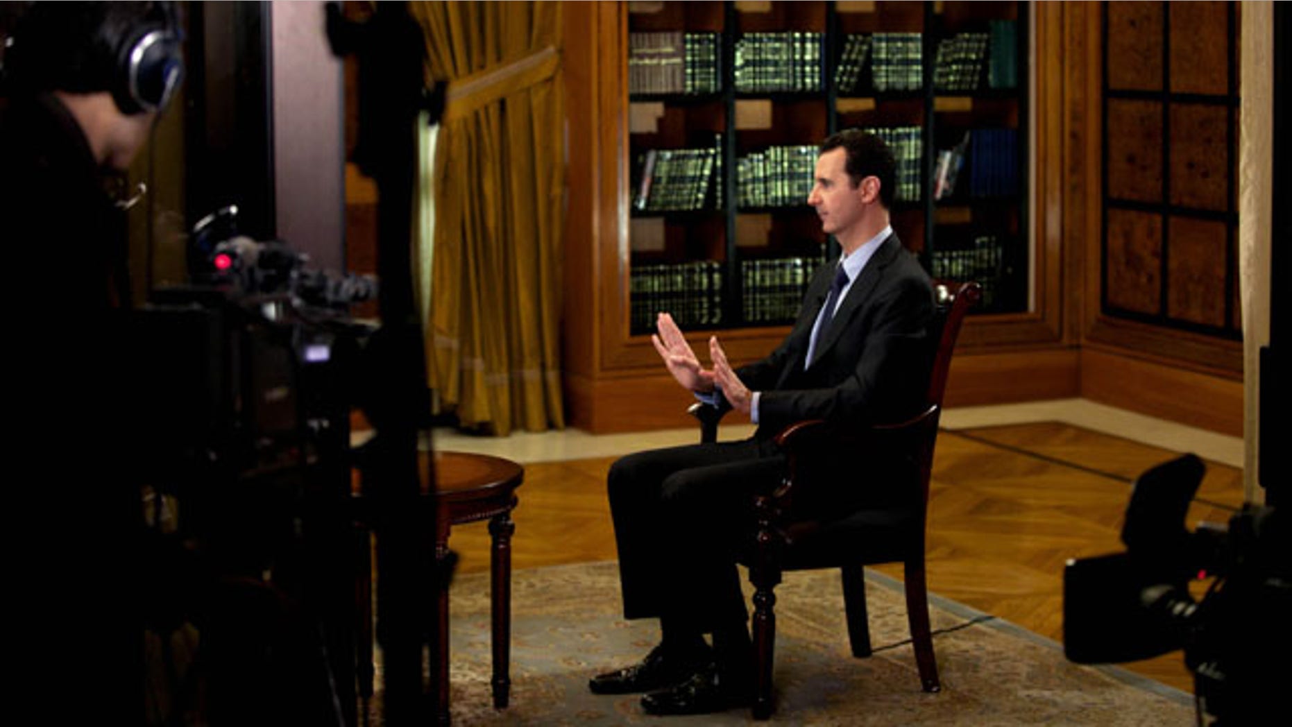 October 21, 2013: In this photo, which AP obtained from Syrian official news agency SANA and which has been authenticated based on its contents and other AP reporting, President Bashar Assad gestures as he speaks during an interview with Lebanon’s Al-Mayadeen TV, at the presidential palace in Damascus, Syria, Monday. (AP Photo)