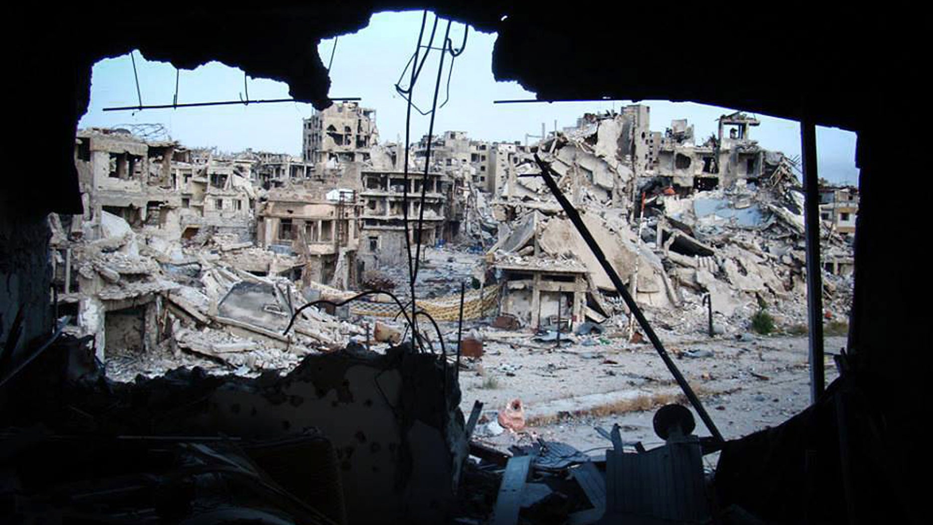 June 5, 2013: In this citizen journalism image provided by Lens Young Homsi, which has been authenticated based on its contents and other AP reporting, shows damaged buildings are seen in the Jouret al-Chiyah neighborhood, Homs province, central Syria.