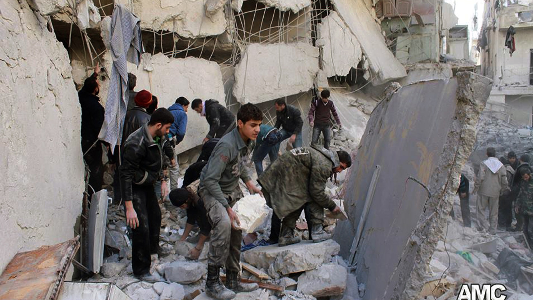 Jan. 31, 2014: In this citizen journalism image provided by Aleppo Media Center (AMC), an anti-Bashar Assad activist group, which has been authenticated based on its contents and other AP reporting, Syrians inspect the rubble of destroyed buildings following a Syrian government airstrike in Aleppo, Syria.