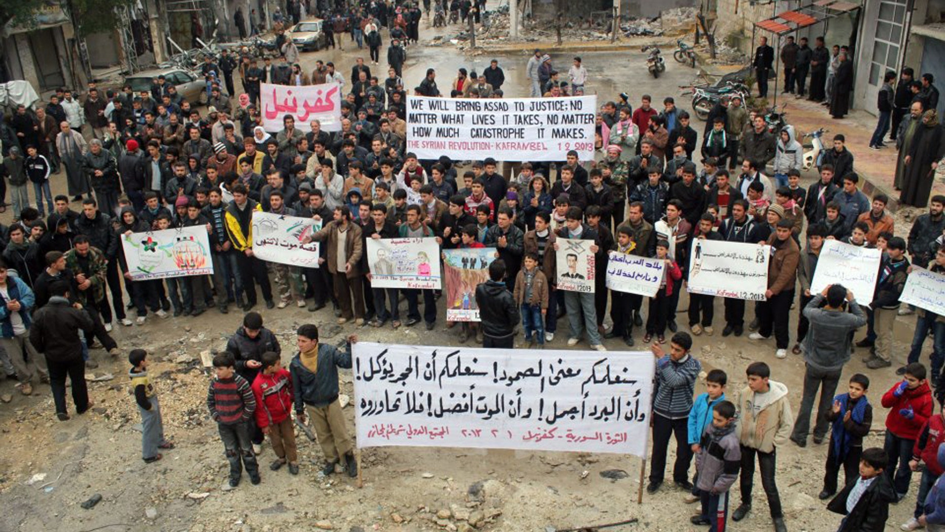 Feb. 1, 2013: This citizen journalism image provided by Edlib News Network, ENN, which has been authenticated based on its contents and other AP reporting, shows anti-Syrian regime protesters carrying banners during a demonstration, at Kafr Nabil town, in Idlib province, northern Syria.