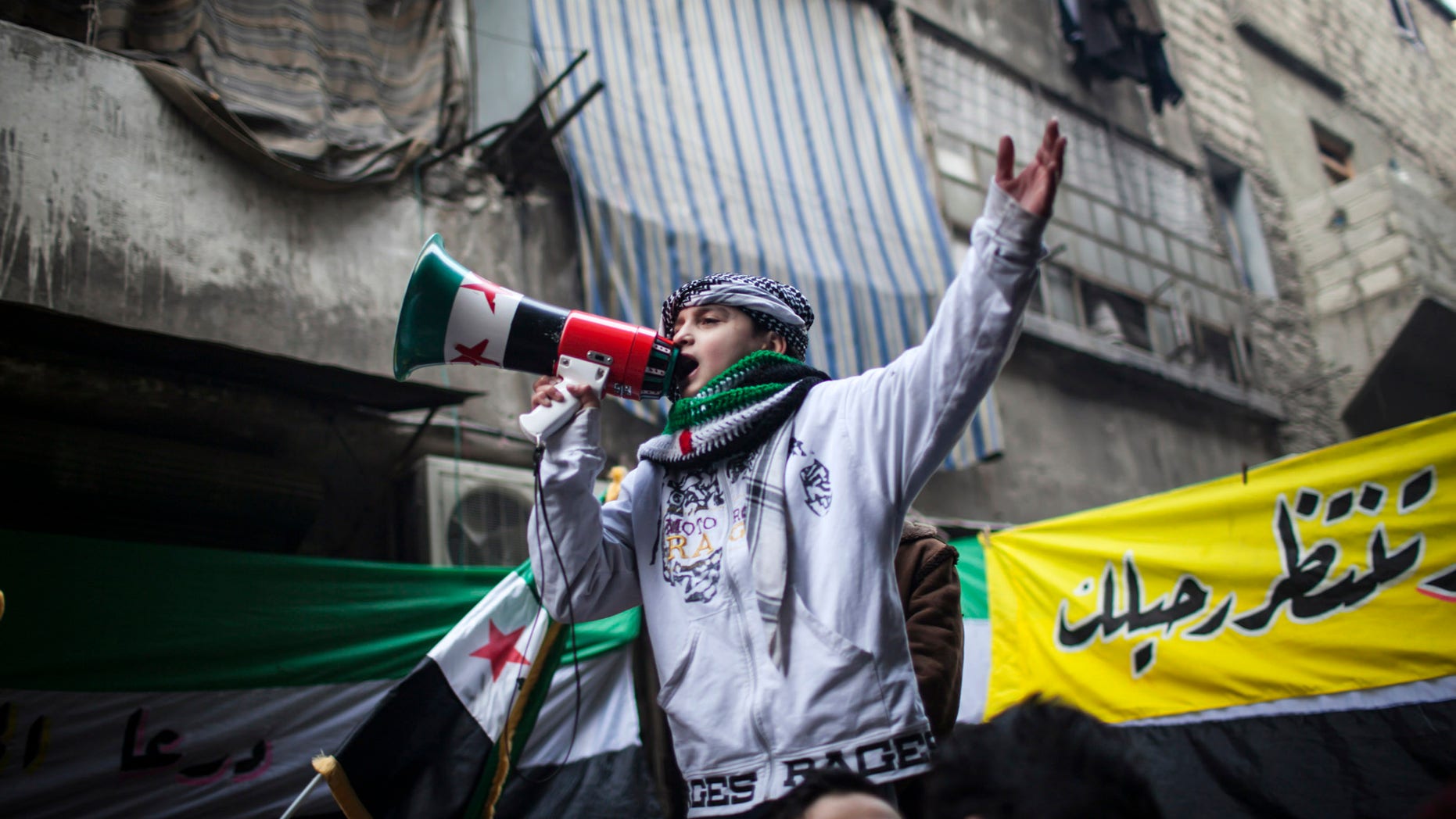 Jan. 4, 2012: A child uses a megaphone to lead others in chanting Free Syrian Army slogans during a demonstration in the neighborhood of Bustan Al-Qasr, Aleppo, Syria.