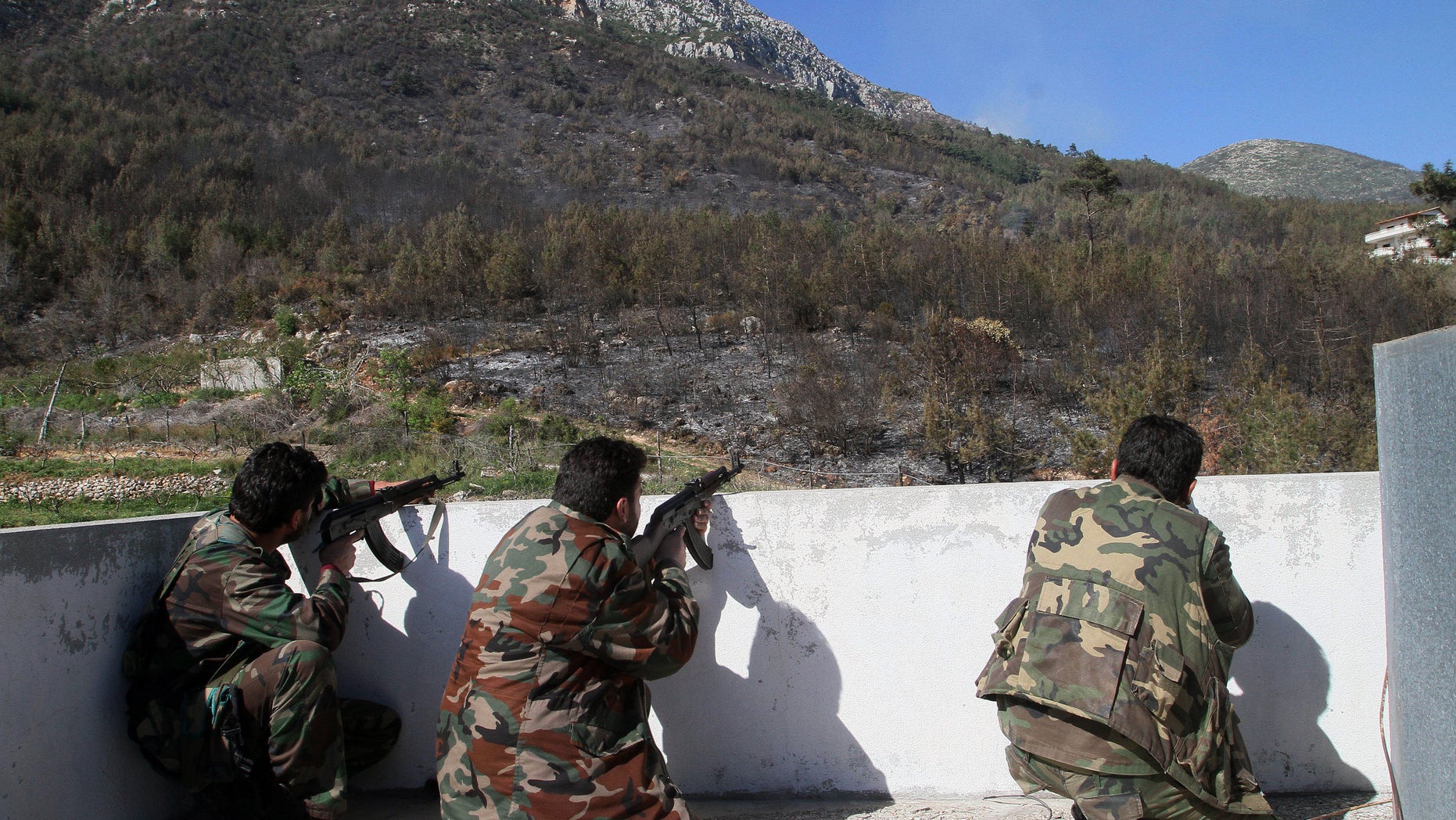 March 27, 2014: In this photo Syrian government soldiers take position during clashes with rebels in Misherfeh town in the province of Latakia, Syria.