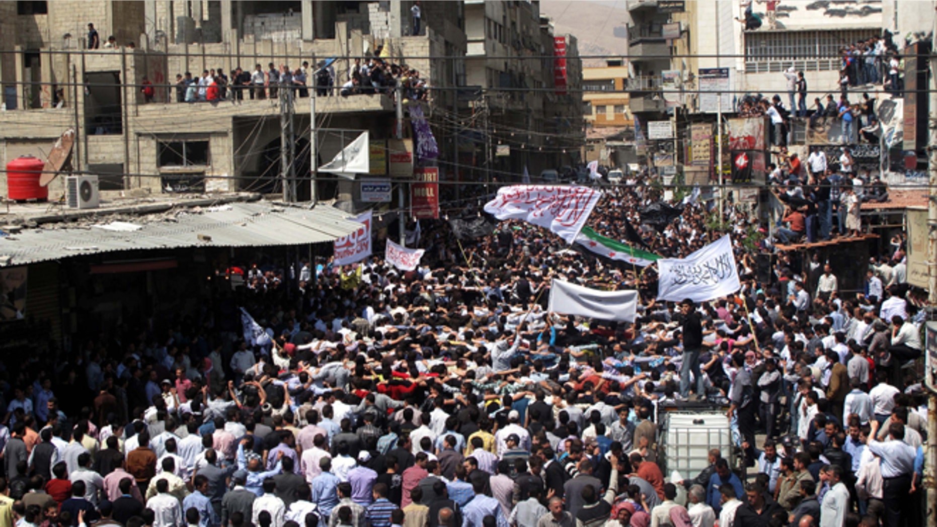 April 20, 2012: Syrians wave Islamic and revolutionary flags at a large protest in Douma, a suburb of Damascus, Syria.