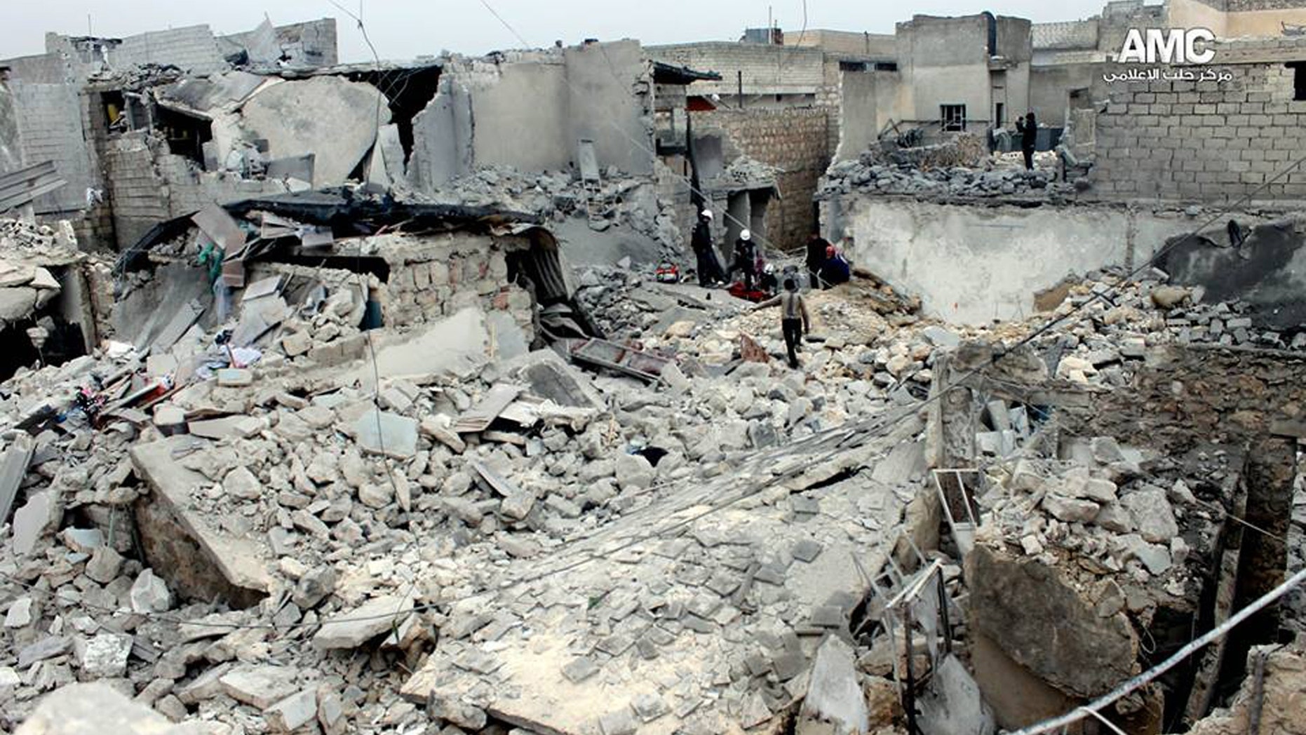 Jan. 23, 2014 - An anti-Bashar Assad activist group, Syrian residents and rescue workers check the rubble of houses damaged, attacked by the Syrian forces airplanes in Aleppo, Syria. (Aleppo Media Center, AMC)
