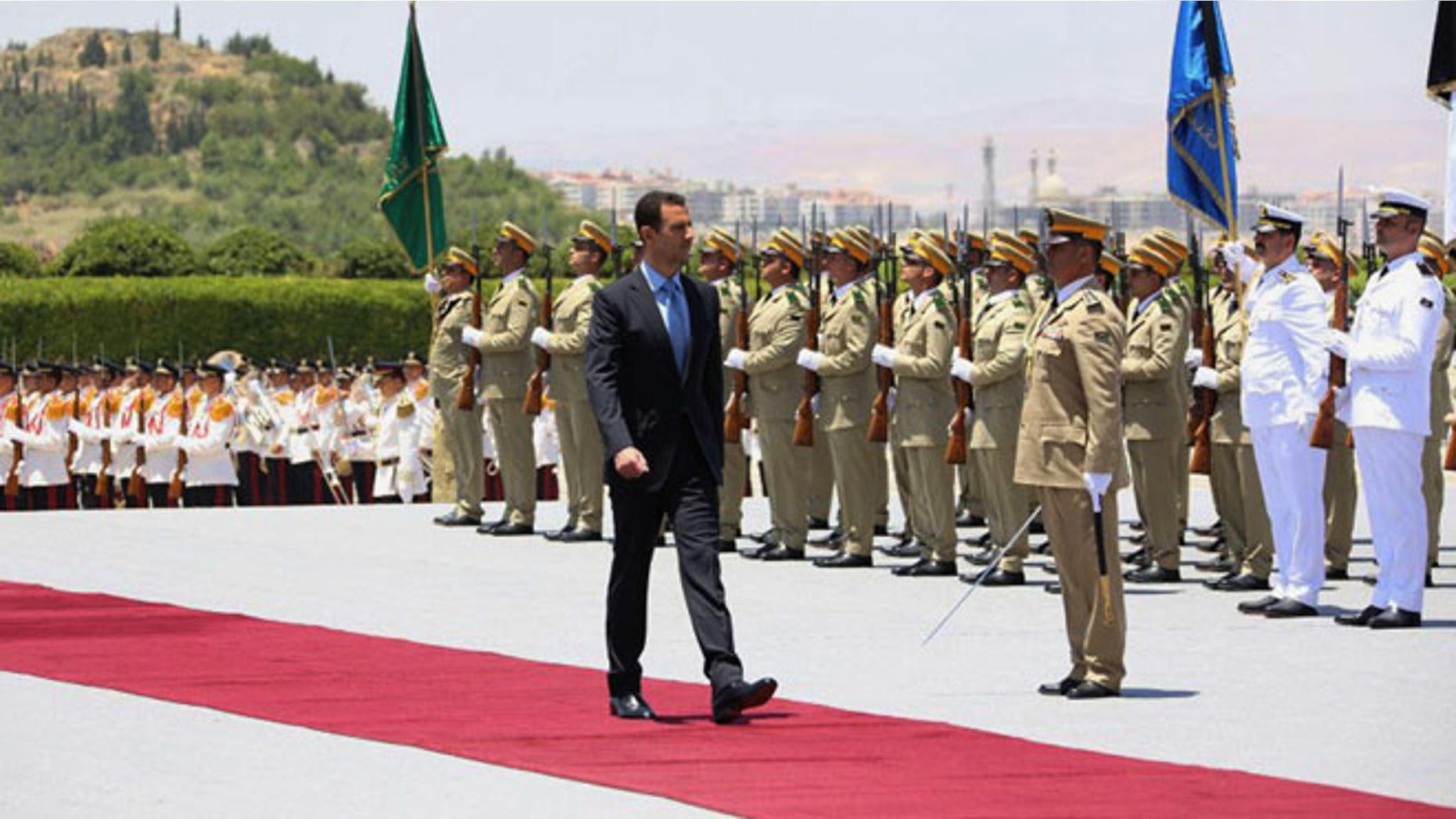 In this photo released by the Syrian official news agency SANA, Syria's President Bashar Assad reviews an honor guard upon his arrival at the presidential palace to take the oath of office for his third seven-year term in Damascus, Syria, Wednesday, July 16, 2014.