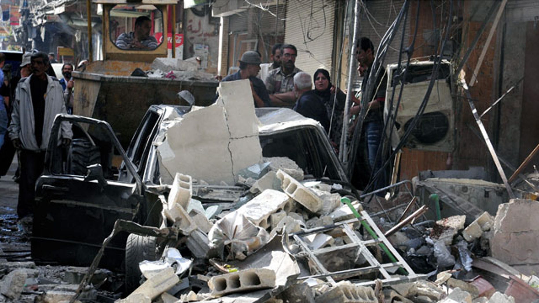 In this photo released by the Syrian official news agency SANA, Syrian citizens gather at the scene of a car bomb exploded in in Damascus, Tuesday September 24, 2013.