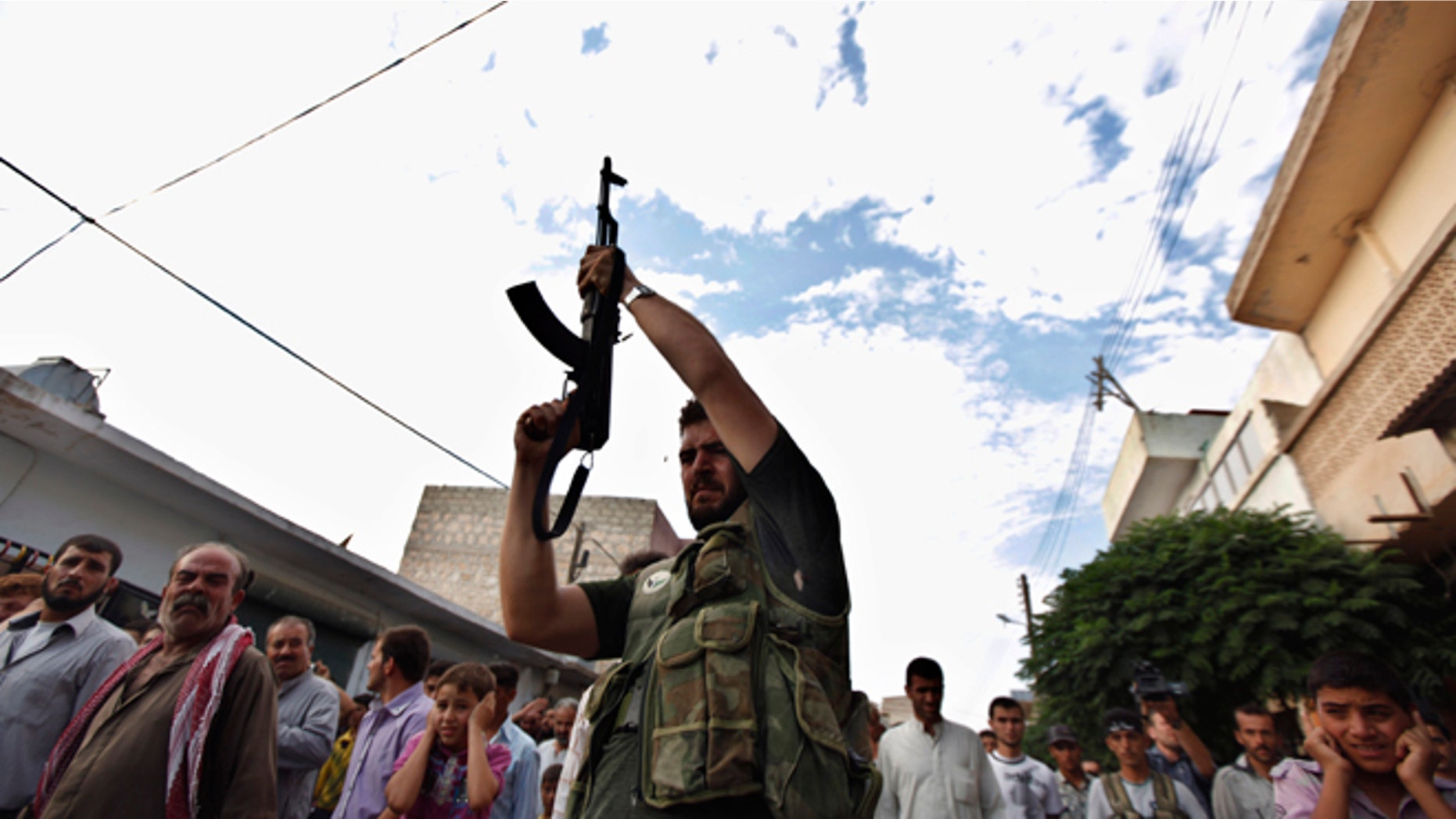 Aug. 9, 2012: A Syrian gunman shoots in the air during the funeral of 29 year-old Free Syrian Army fighter, Husain Al-Ali, who was killed during clashes in Aleppo, in the town of Marea on the outskirts of Aleppo city, Syria.