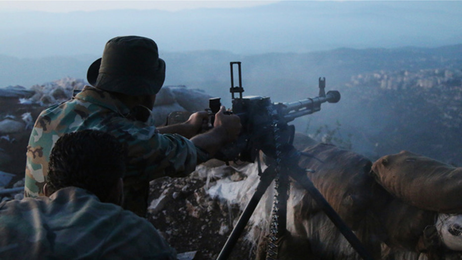 Oct. 10, 2015: Syrian army personnel fire a machine gun in Latakia province, about 12 miles from the border with Turkey, Syria.