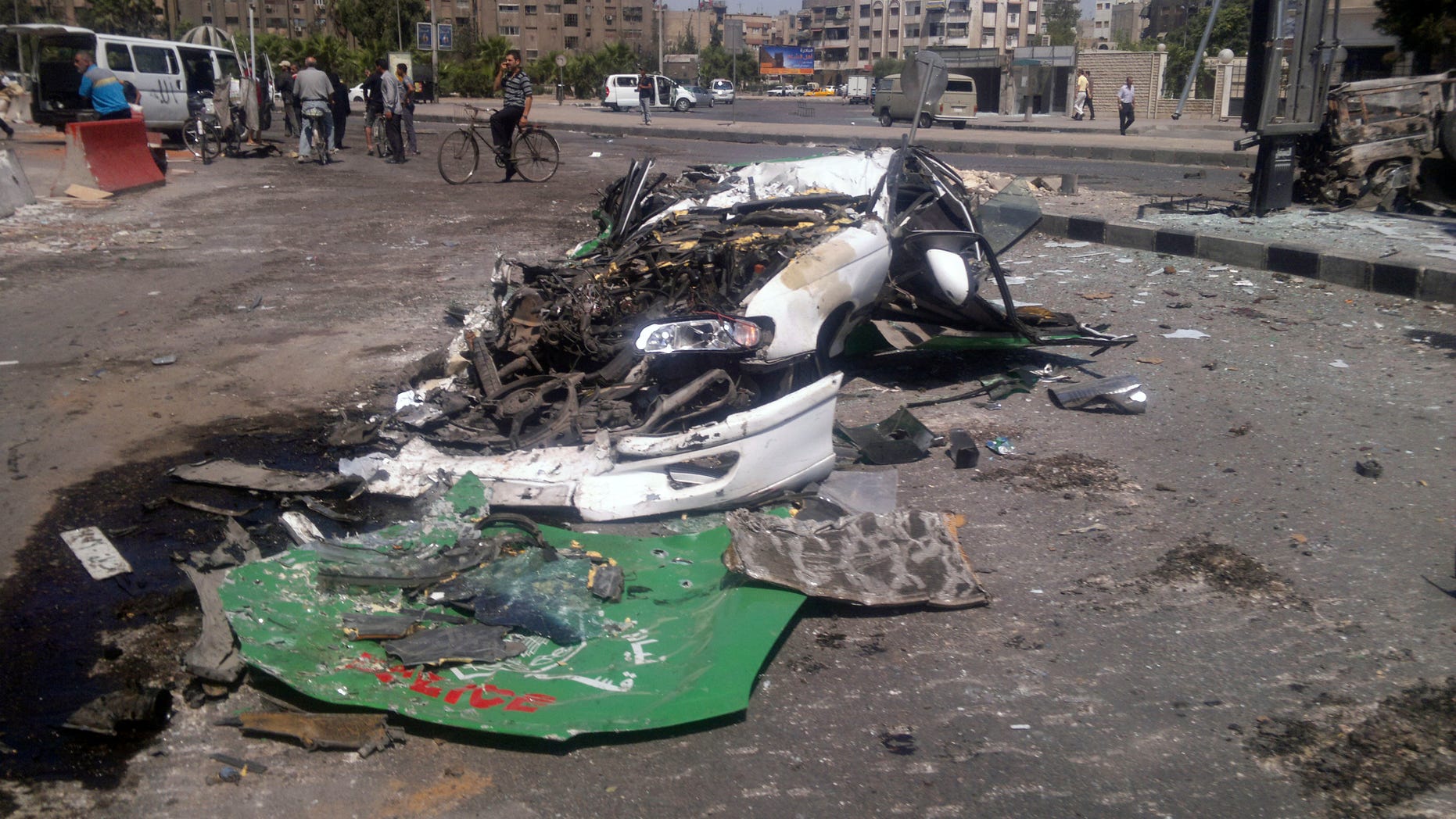 July 21, 2012: This citizen journalist image shows a destroyed car on a street damaged by tank treads after fighting between rebels and Syrian troops in the Yarmouk camp for Palestinian refugees in south Damascus, Syria.