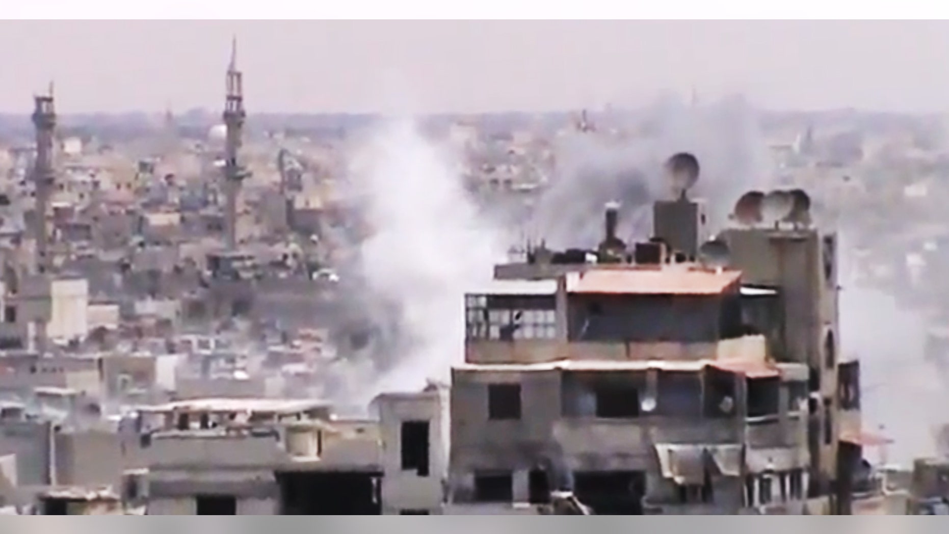 June 18, 2012: This image made from amateur video released by the Shaam News Network, purports to show smoke rising from buildings in Homs, Syria.