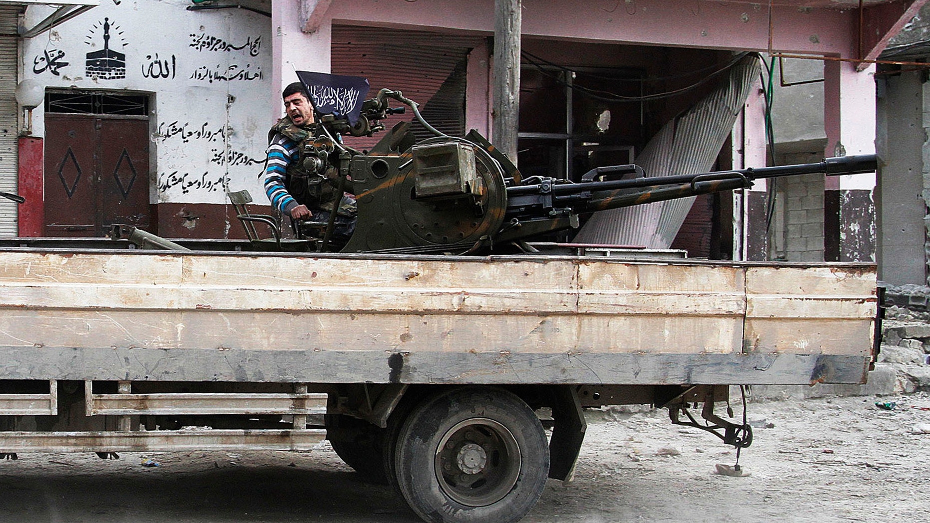 February 8, 2013- Free Syrian Army fighter sits behind an anti-aircraft weapon in Aleppo, Syria.