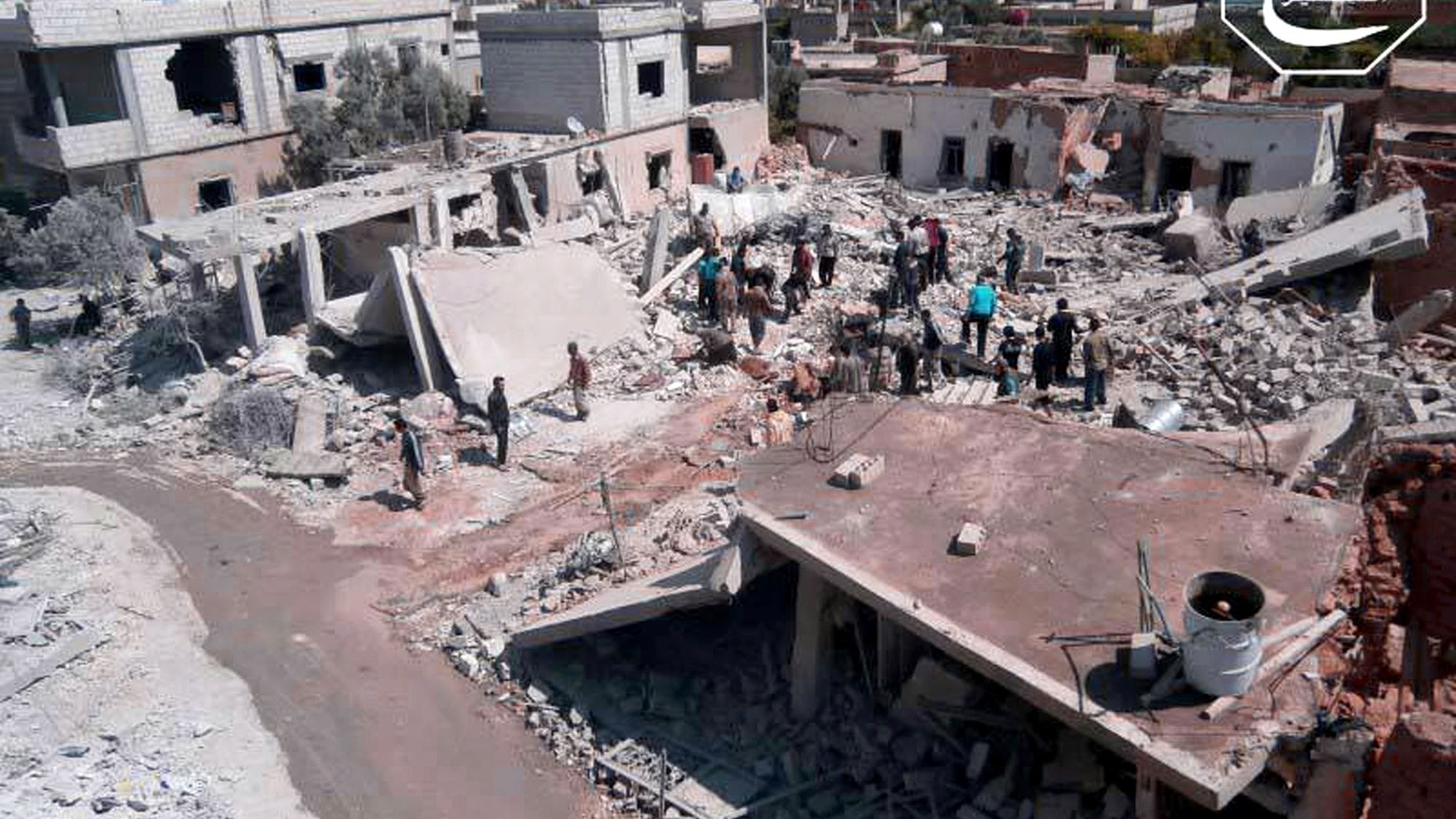 May 21, 2013 - FILE citizen journalism image provided by Qusair Lens, shows Syrian citizens gathering over houses that were destroyed by a Syrian forces air strike in the town of Qusair, near the Lebanon border.