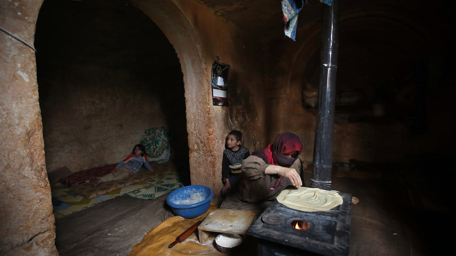 Feb. 28, 2013 - Nadia, 53, makes bread on a wooden stove, at an underground Roman tomb which she uses as a shelter with her family from Syrian government forces shelling and airstrikes.