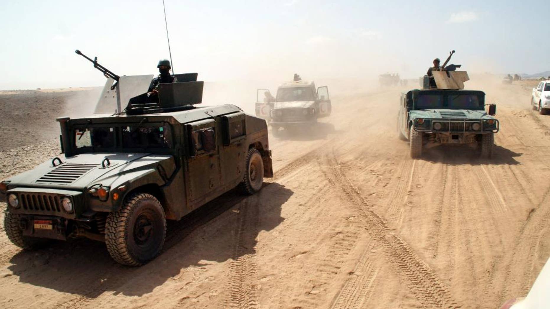 In this photo provided by Yemen's Defense Ministry, Yemeni army vehicles take position on the frontline of fighting with al-Qaida in the southeastern province of Shabwa, Yemen, Thursday, May 8, 2014. Yemeni armed forces on Thursday swept al-Qaida fighters out of a district in the country's south, one of the main goals of the major offensive waged by the military the past two weeks, the Defense Ministry said, amid fears of retaliatory attacks which officials say prompted the closure of the US embassy in the capital as a precaution. (AP Photo/Yemen's Defense Ministry)