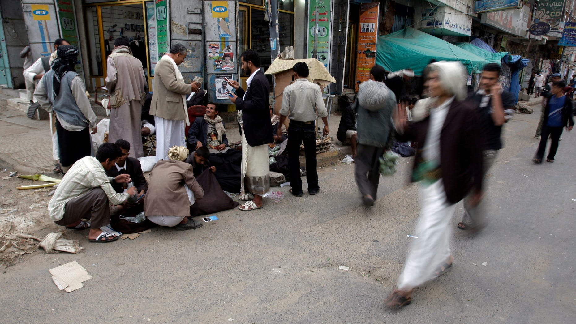 August 29: Yemenis walk past vendors selling Qat next to the site of anti-government protestors demanding the resignation of Yemen's President Ali Abdullah Saleh, in Sanaa, Yemen.