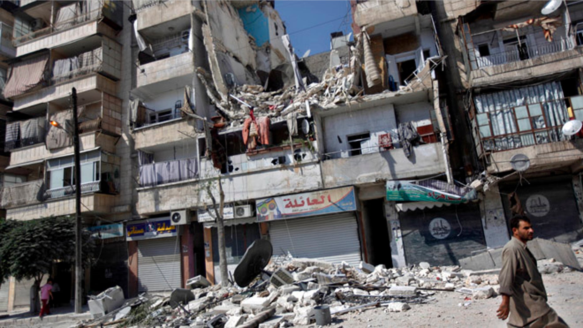Aug. 17, 2012: A Syrian man walks by a building destroyed in an airstrike in Aleppo city, Syria.