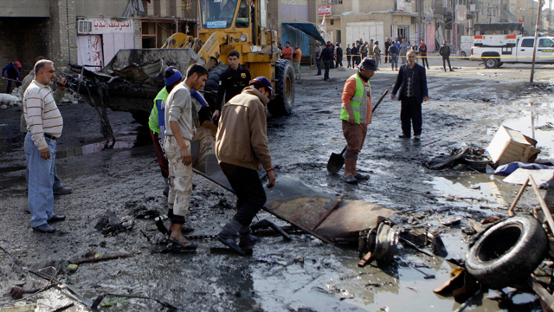 Jan. 27: People clean the scene of a car bomb attack in Zafaraniyah, Baghdad.