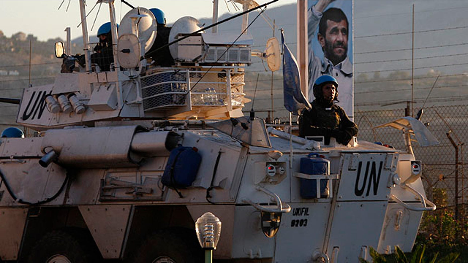 Oct. 12, 2010: U.N. peacekeepers patrol the border in front of an attached picture of Iranian President Mahmoud Ahmadinejad, a day ahead of his visit, in the southern border village of Kfar Kila, Lebanon.