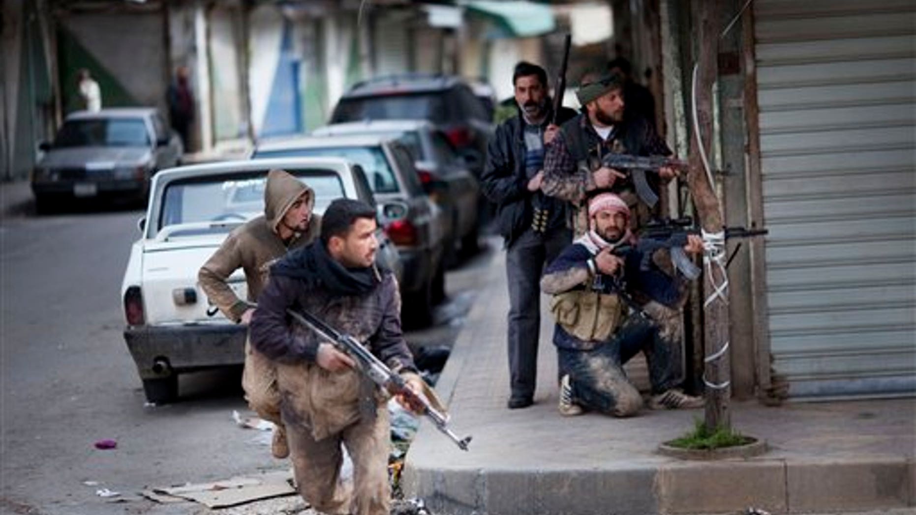 In this Sunday, March 11, 2012 photo, Syrian rebels take position during clashes with government forces in Idlib, north Syria. (AP Photo/Rodrigo Abd)