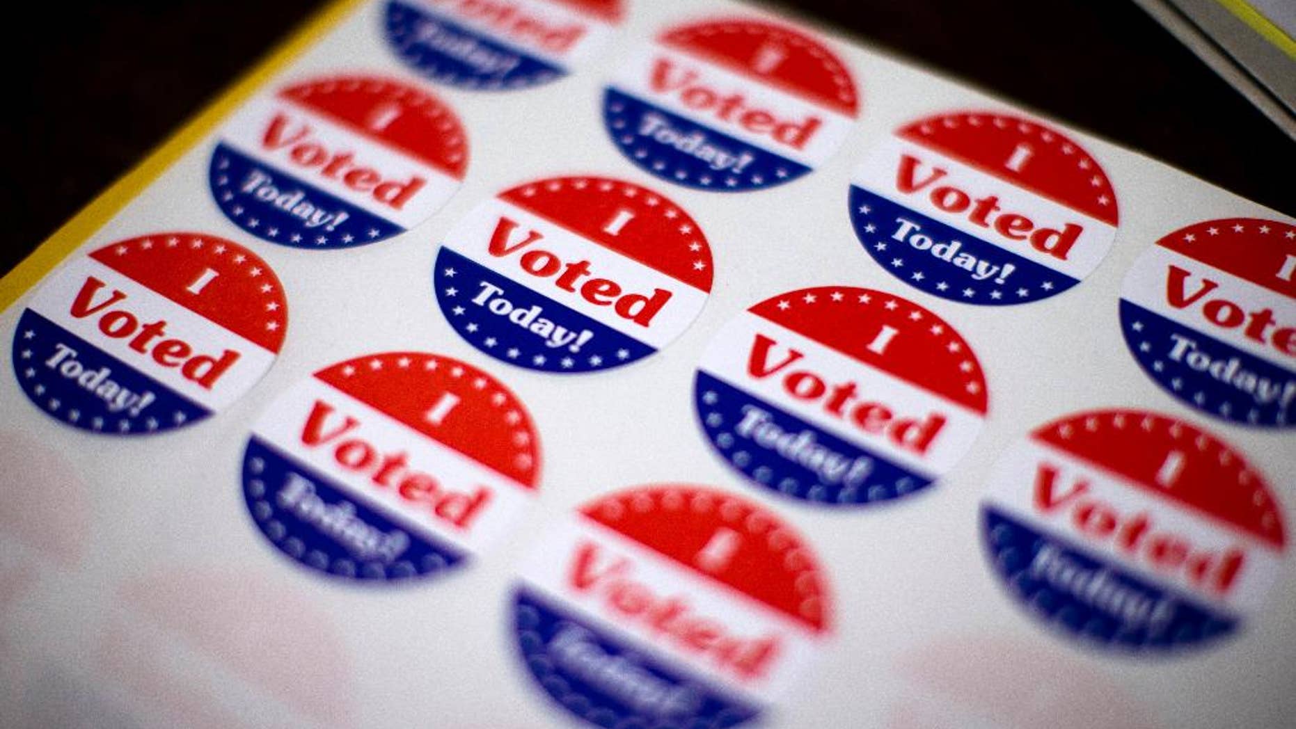 FILE - In this Nov. 5, 2013 file photo, stickers wait for voters at a polling place in Philadelphia. Two weeks before election day, the nation’s likely voters have started seeing eye-to-eye with the election prognosticators. Most now expect the Republican Party to take control of the U.S. Senate, according to a new Associated Press-GfK poll. And by a growing margin, more say that’s the outcome they’d like to see. (AP Photo/Matt Rourke, File)