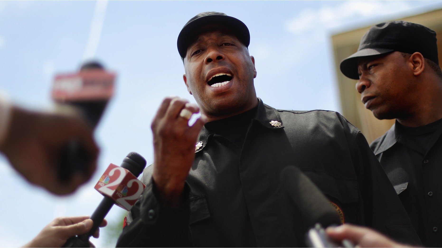 Mikhail Muhammad of the New Black Panther Party speaks on Saturday to the media next to a memorial to Trayvon Martin outside The Retreat at Twin Lakes community where Trayvon was shot and killed by George Michael Zimmerman while on neighborhood watch patrol. (Photo by Mario Tama/Getty Images)