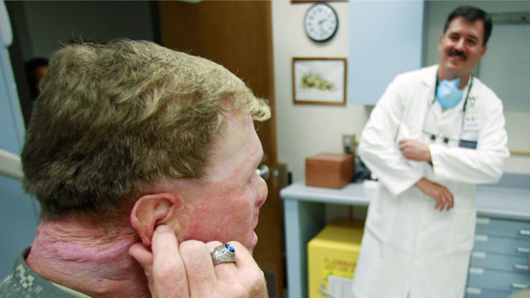 June 23: Master Sgt. Todd Nelson, left, visits with Dr. Joe Villalobos, right, during a visit to makes adjustments to a prosthetics ear at Wilford Hall Medical Center in San Antonio. Nelson was injured in 2007 by an explosion while serving in Afghanistan. (AP)