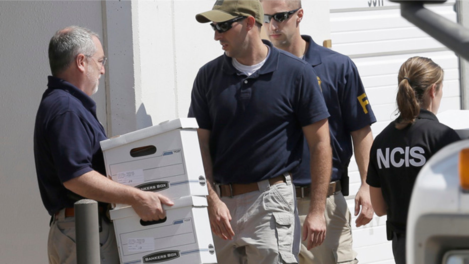 Oct. 3, 2012: Federal agents carry boxes out of Arc Electronics Inc. , in Houston.