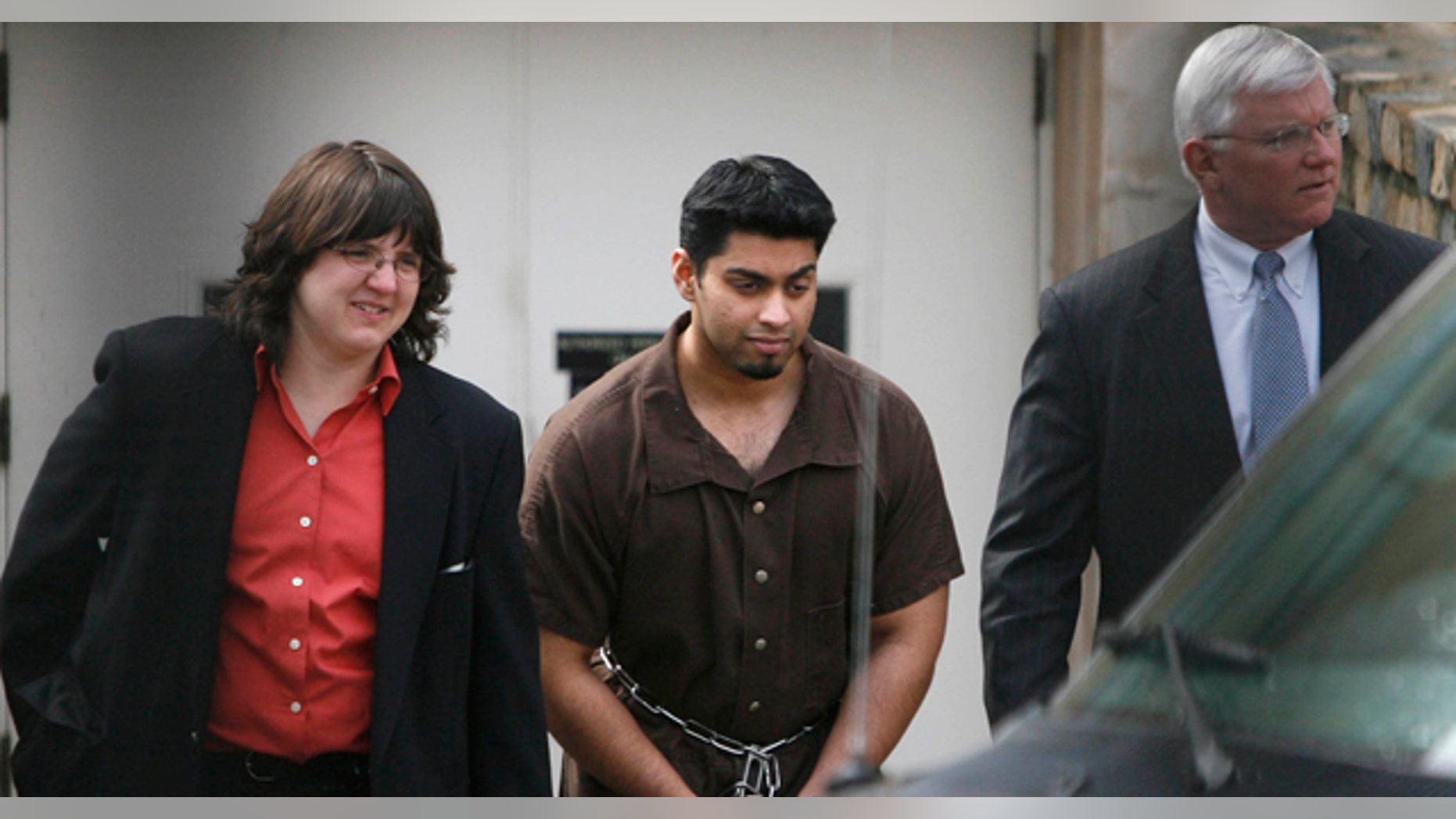 In this March 21, 2007 photo, taken through a fence, Khaleel Ahmed, 26, of Chicago, is led out of the Federal Courthouse in Toledo, Ohio, by a federal agent and accompanied by an attorney. (AP)