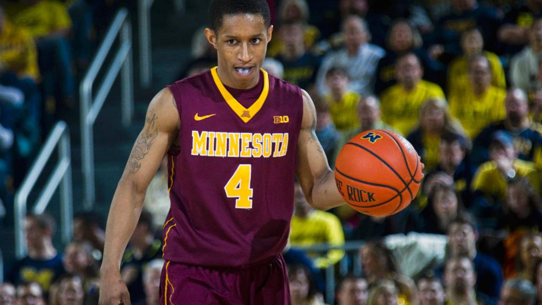 FILE - In this March 1, 2014 file photo, Minnesota guard Deandre Mathieu (4) dribbles the ball in the second half of an NCAA college basketball game against Michigan in Ann Arbor, Mich. Minnesota enters the Big Ten tournament needing a win or two to secure that elusive NCAA tournament berth, and the fate of the Gophers will rest largely on the small shoulders of Mathieu. (AP Photo/Tony Ding, File)