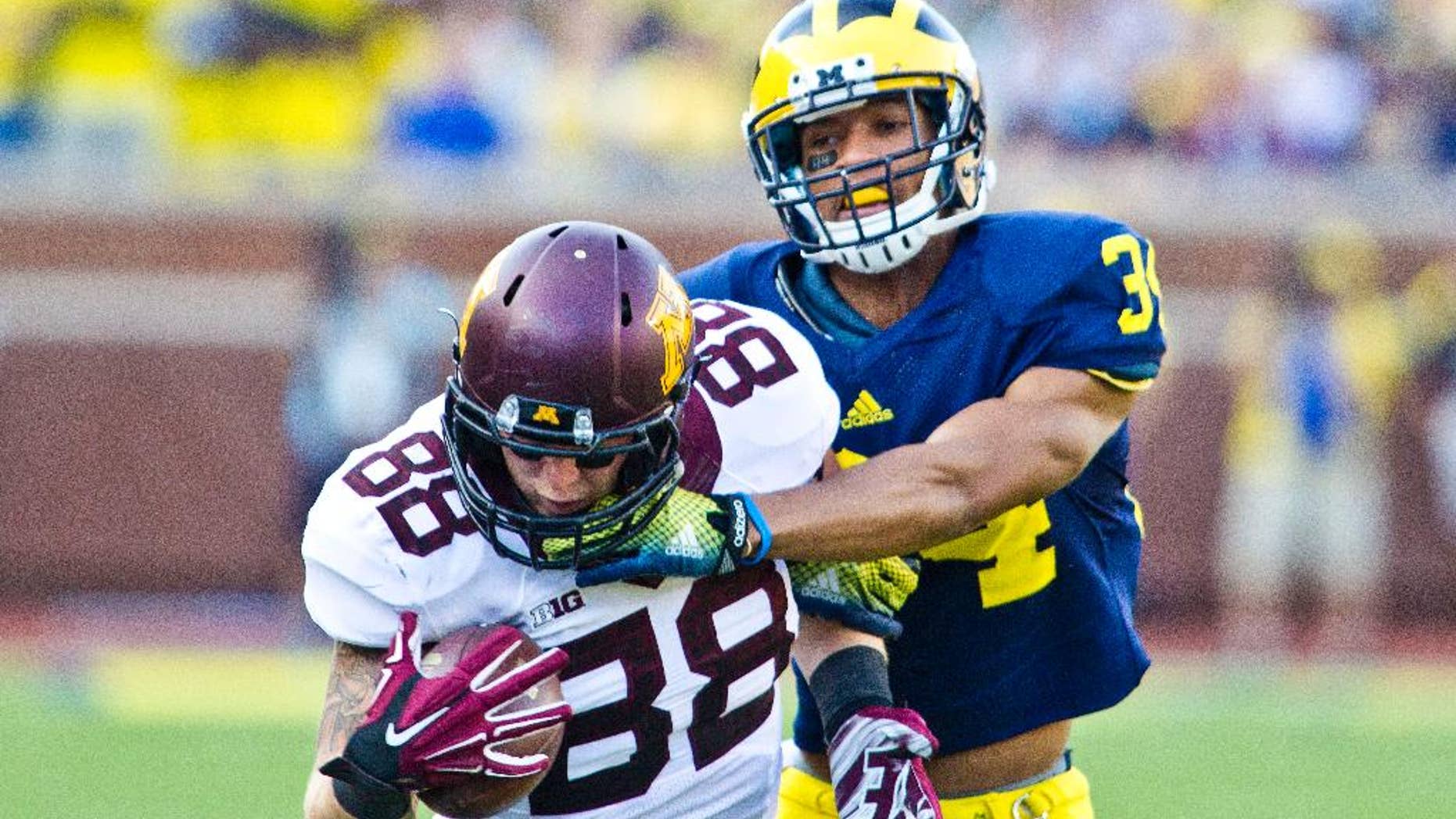 Minnesota tight end Maxx Williams (88) makes a one-handed catch while defended by Michigan defensive back Jeremy Clark (34) in the third quarter of an NCAA college football game in Ann Arbor, Mich., Saturday, Sept. 27, 2014. Minnesota won 30-14. (AP Photo/Tony Ding)