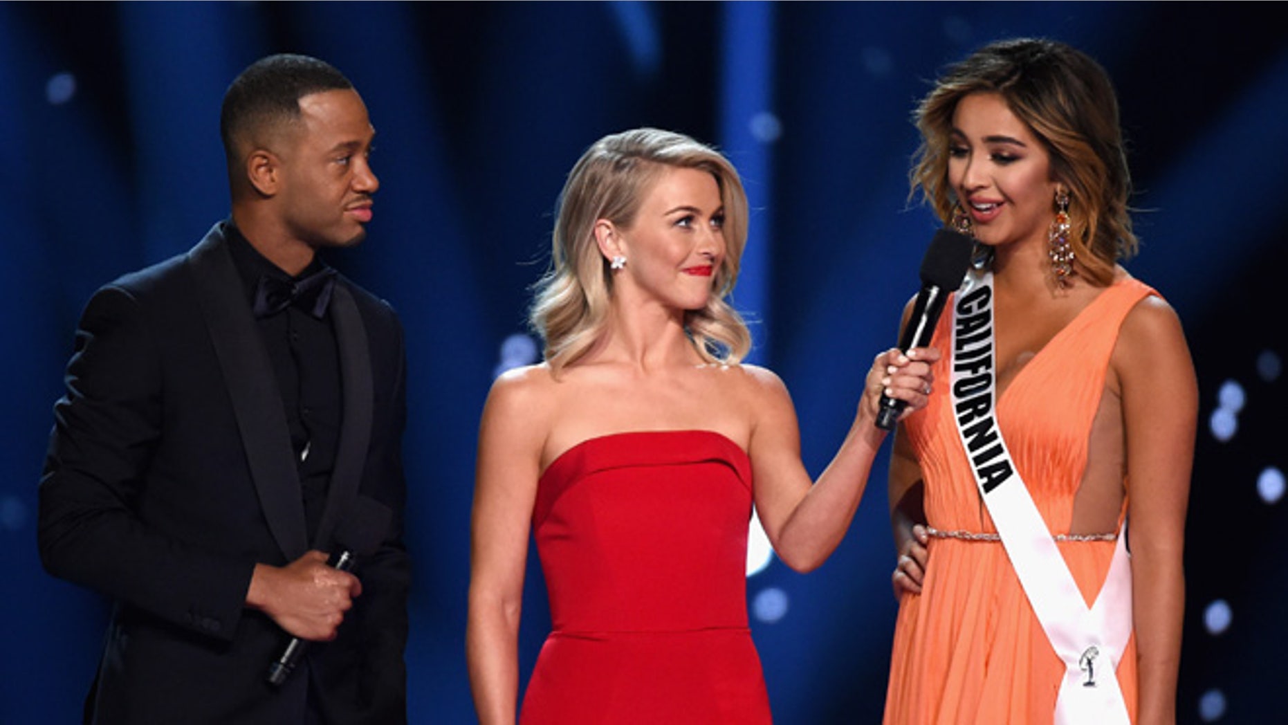 LAS VEGAS, NV - JUNE 05: Miss California USA 2016 Nadia Mejia (R) competes in the interview portion as hosts Terrence J (L) and Julianne Hough (C) speak onstage during the 2016 Miss USA pageant at T-Mobile Arena on June 5, 2016 in Las Vegas, Nevada. (Photo by Ethan Miller/Getty Images)