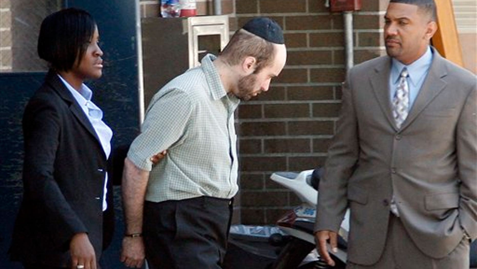July 14: Detectives walk Levi Aron, center, to a police car at the Brooklyn borough of New York's 67th precinct.