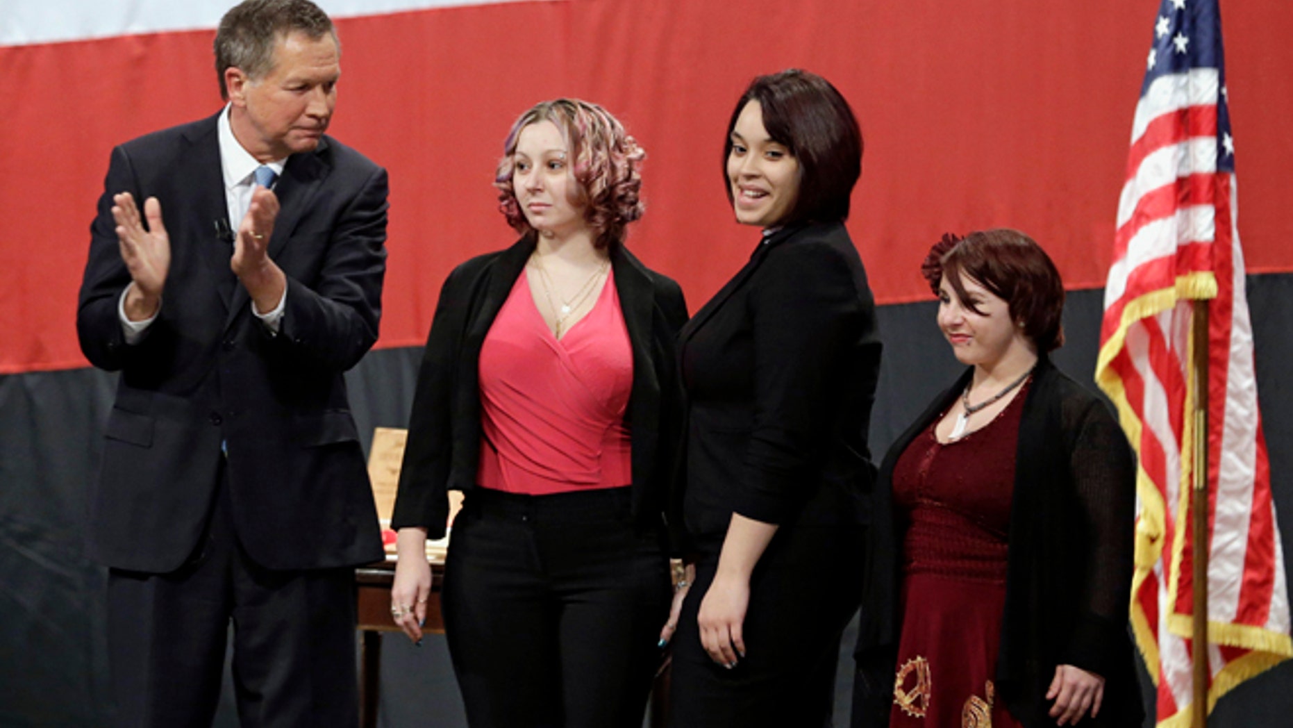 FILE- This Monday, Feb. 24, 2014 file photo shows Ohio Gov. John Kasich, from left, introducing Amanda Berry, Gina DeJesus and Michelle Knight during his State of the State address at the Performing Arts Center in Medina, Ohio. Berry broke through a screen door to freedom last May. Upstairs, officers found DeJesus and Knight. They had been snatched off the streets separately between 2002 and 2004 and locked inside Castroâs house where he chained and raped them, investigators later said. (AP Photo/Tony Dejak, File)