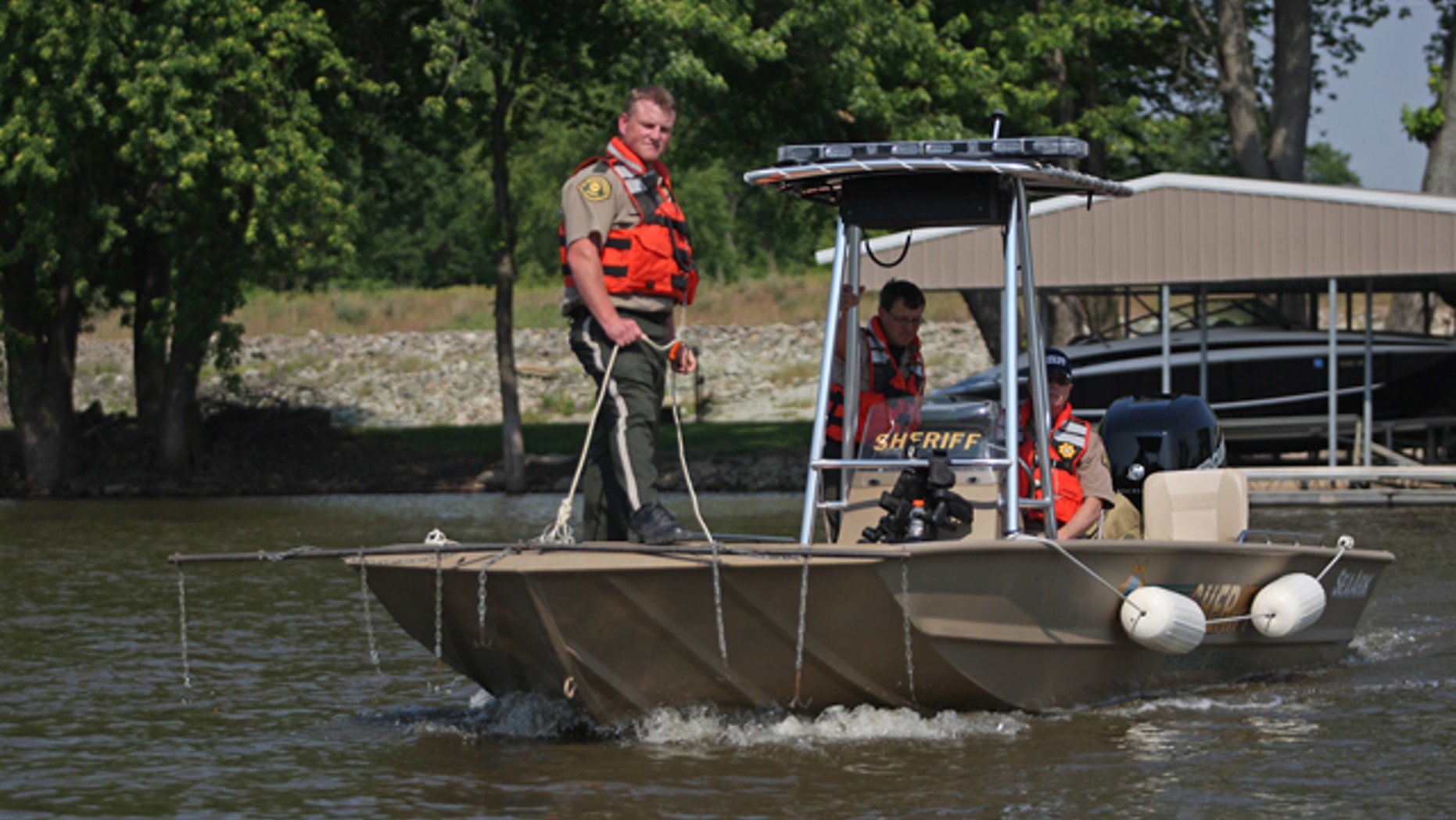 May 19, 2012: Des Moines County officer Kevin Glendening, foreground, drags the Mississippi River as officer Brad Siegfried, center, and Sheriff Mike Johnstone use sonar to locate four missing people near O'Connel Slough near Burlington, Iowa.